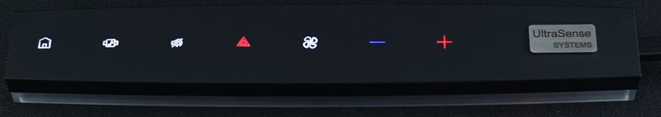 A slim black control bar with seven icons lit along it -- home, media, defrost, hazard, fan, and a minus and plus pair -- glowing through an unbroken surface.