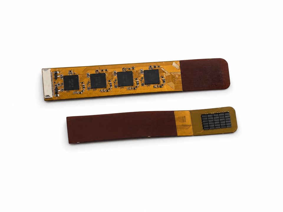 Two flexible circuit sensor strips, each carrying a row of square sensor tiles and ending in a gold-pad connector tail, on a clean white ground.