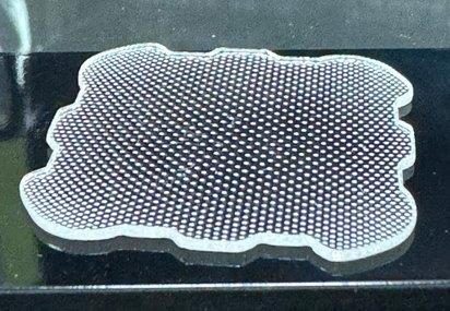 A macro of a piezoelectric transducer tile, thousands of circular elements in a dense regular grid across its face.